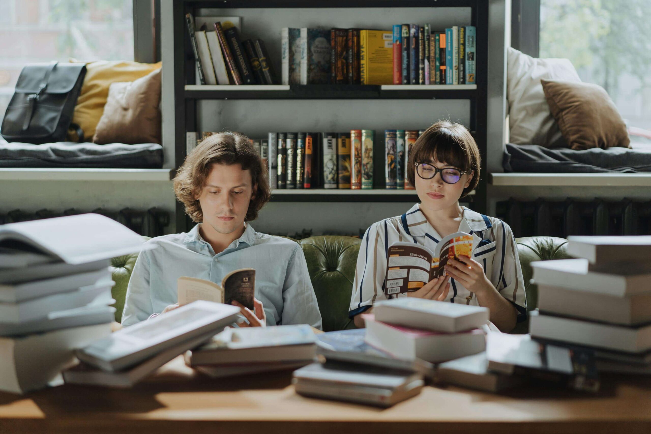 Two introverted friends sitting reading a book trying to make meaningful connections